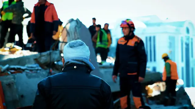 Enkaz başında bekleyen bir adam ve kurtarma ekipleri